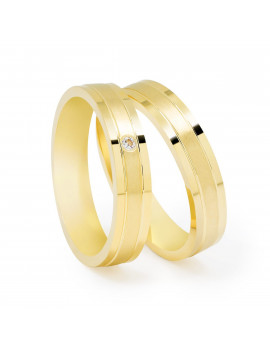 Par de alianzas de boda de oro amarillo con diseño plano, ranuras y acabado satinado; una de ellas con diamante central.