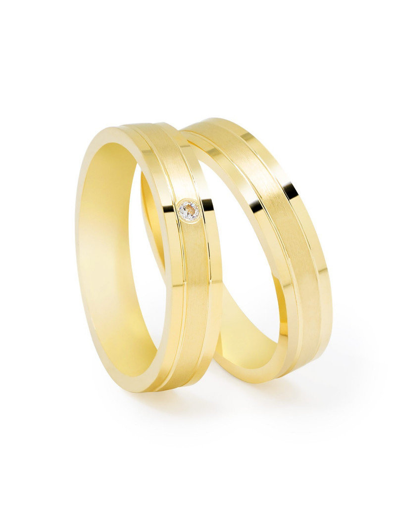 Par de alianzas de boda de oro amarillo con diseño plano, ranuras y acabado satinado; una de ellas con diamante central.