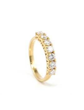 Anillo tipo media alianza Brenda en oro amarillo de 18 quilates con siete diamantes de talla brillante engastados en línea.