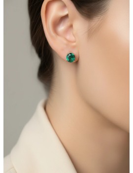 Modelo luciendo los pendientes solitarios Sofia de esmeraldas verdes en oro amarillo.