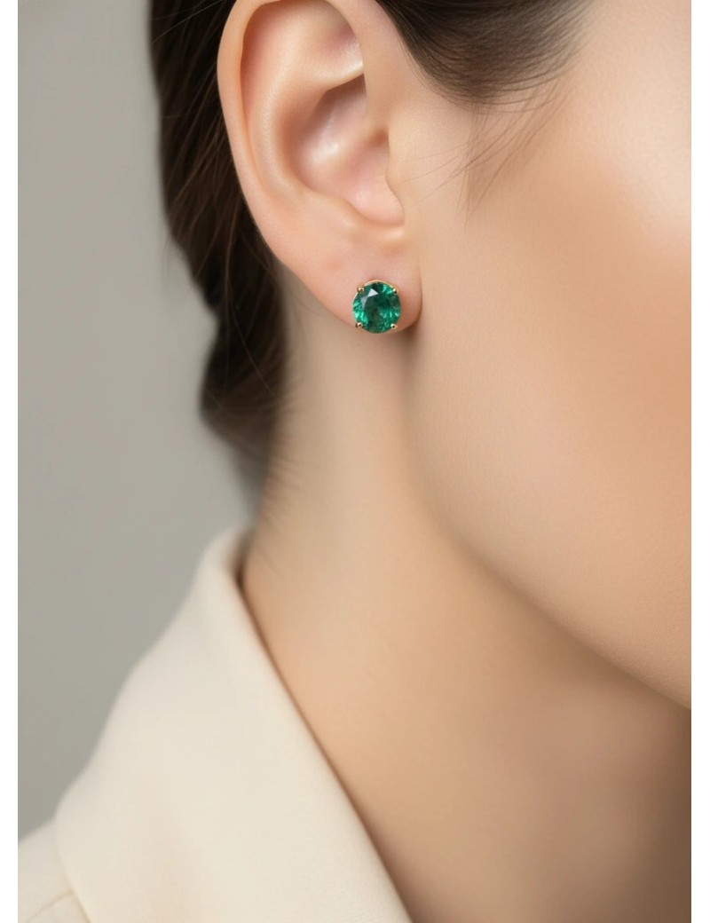 Modelo luciendo los pendientes solitarios Sofia de esmeraldas verdes en oro amarillo.