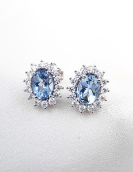 Pendientes de botón Victoria en oro blanco 18k con aguamarinas ovales azul celeste y orla de diamantes brillantes.