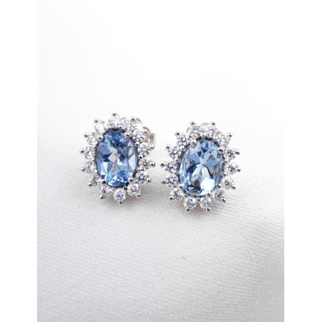 Pendientes de botón Victoria en oro blanco 18k con aguamarinas ovales azul celeste y orla de diamantes brillantes.