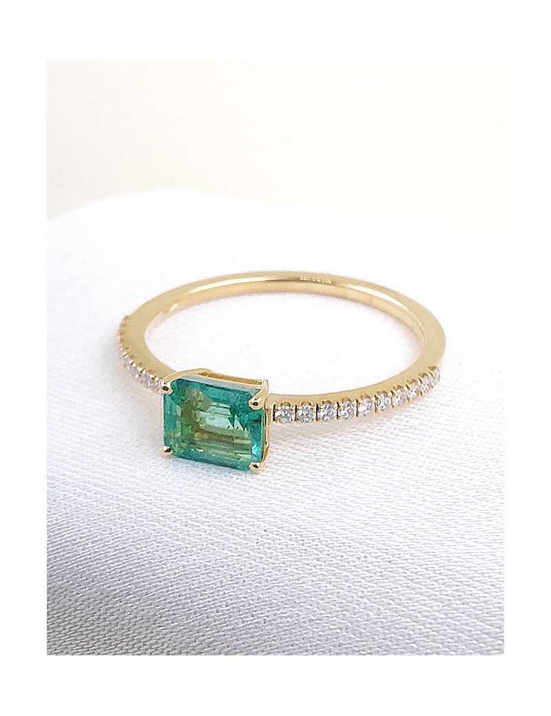Anillo en oro amarillo 18k con esmeralda rectangular de 0.74ct y hombros de diamantes brillantes.