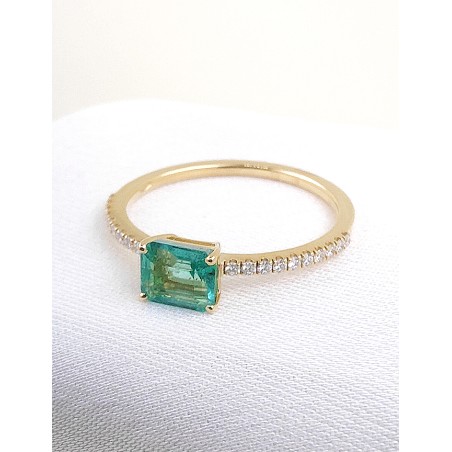 Anillo en oro amarillo 18k con esmeralda rectangular de 0.74ct y hombros de diamantes brillantes.
