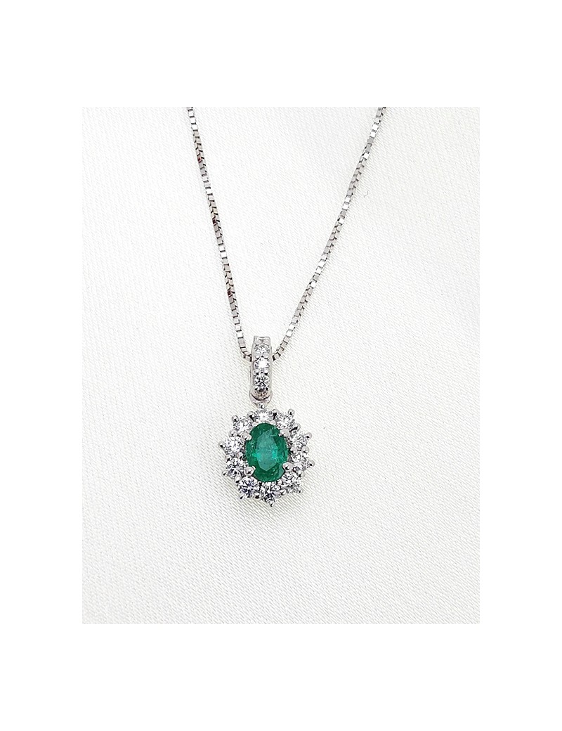 Colgante Victoria de oro blanco 18k con esmeralda ovalada de 0.30ct y halo de diamantes de talla brillante.