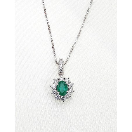 Colgante Victoria de oro blanco 18k con esmeralda ovalada de 0.30ct y halo de diamantes de talla brillante.