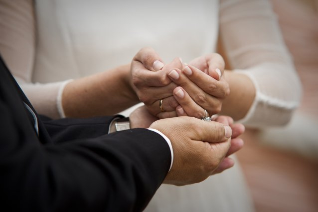 arras pasando de la mano de la novia al novio durante la boda. manos de los novios con arras