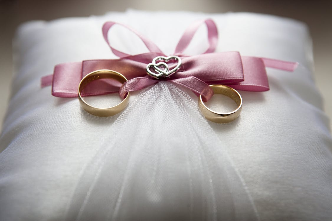 alianzas de boda sobre un bonito porta alianzas color rosa